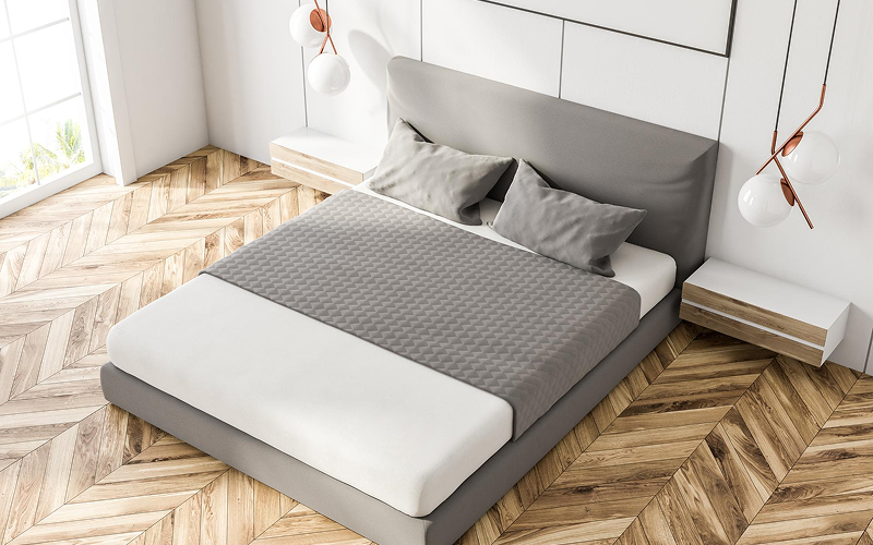 Queen size bed with grey bedding in modern minimalist bedroom.