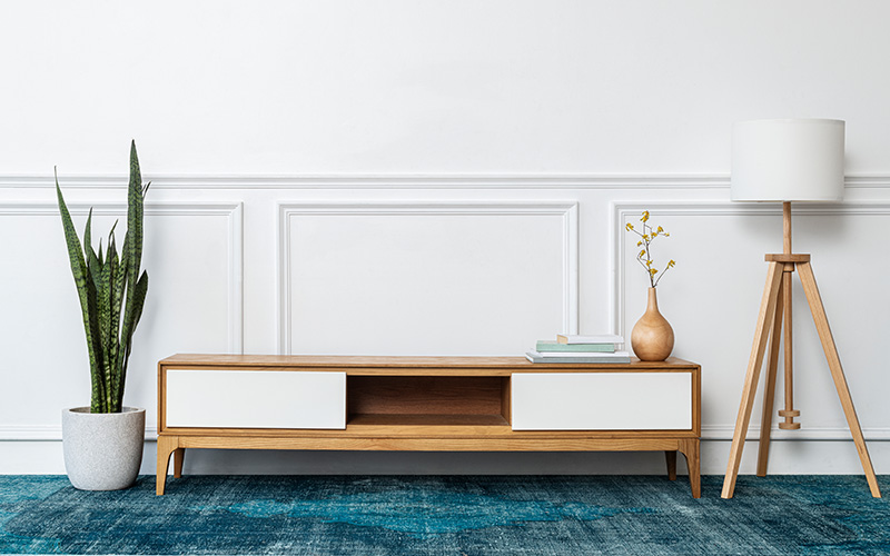 A minimalist wooden TV console with white drawers