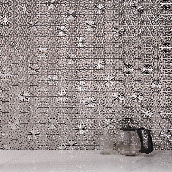 3D hexagon silver metal mosaic tiles on a wall with teacups in the foreground.