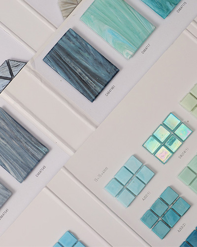 A collection of mosaic tile color palettes neatly stacked, showcasing a range of vibrant colors.
