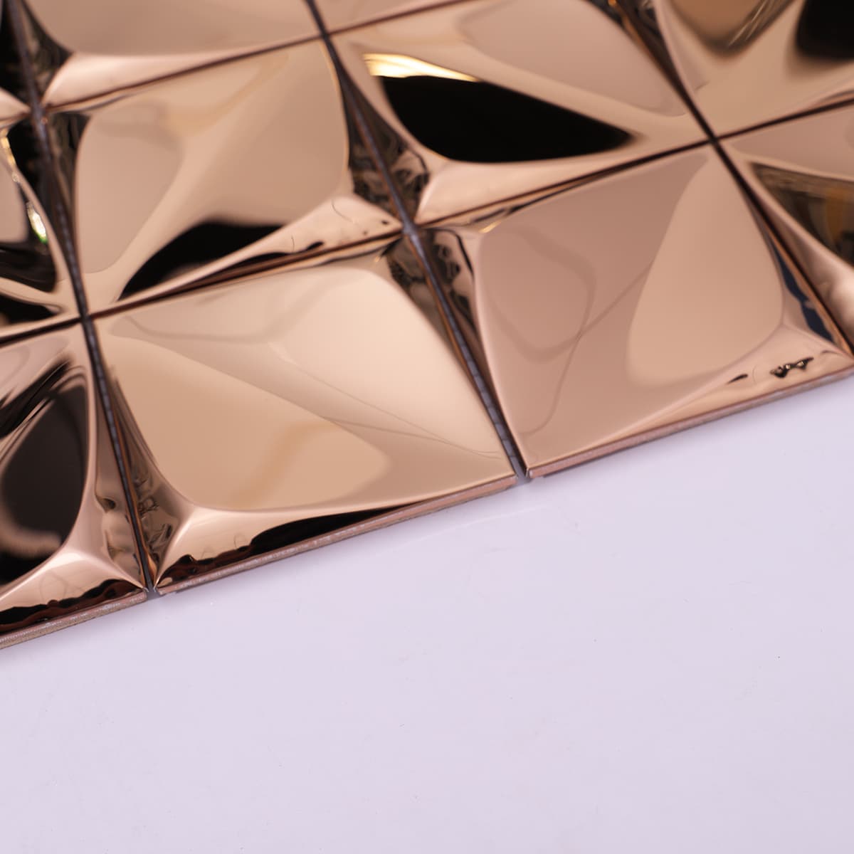 Edge detail of 3D brushed rose gold metal mosaic tile