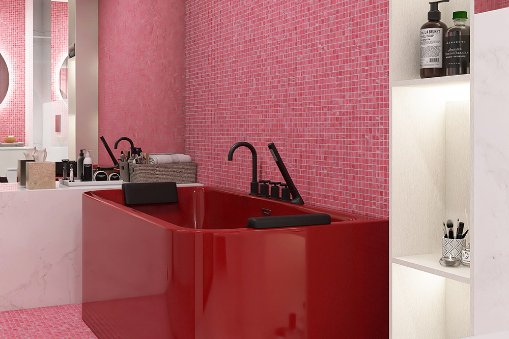 Bathroom wall with pink mosaic tiles next to a red bathtub.
