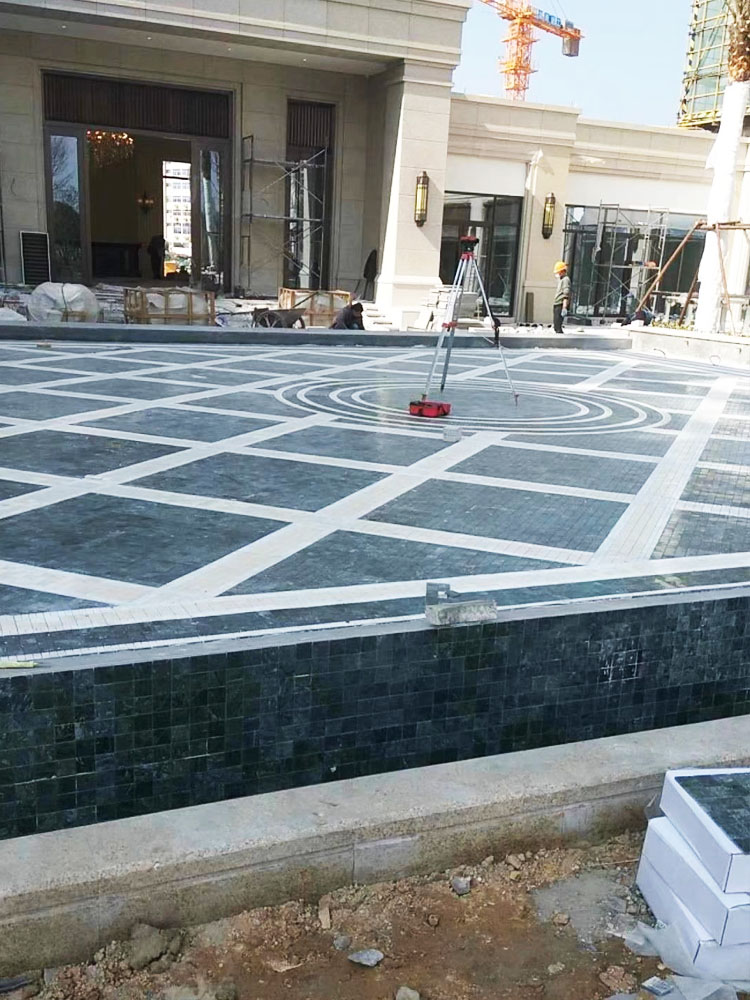 Photo of green natural marble mosaic tiles being installed in the swimming pool.