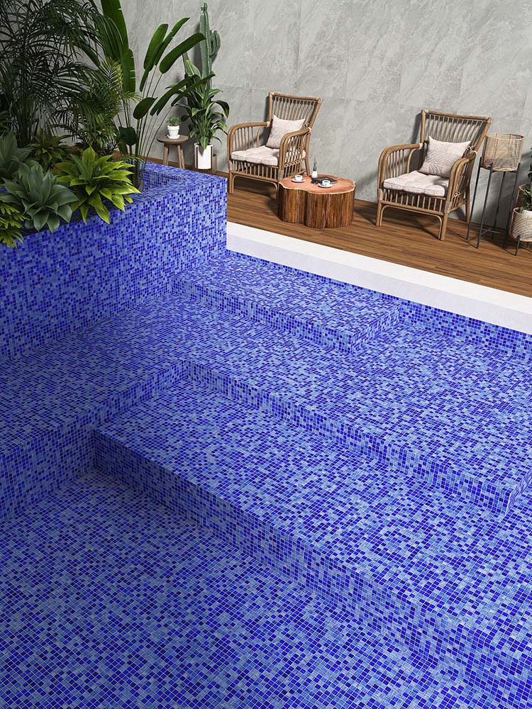 The blue glass mosaic tiles create a serene, sparkling effect in the swimming pool, complemented by a relaxing lounge stool at the poolside
