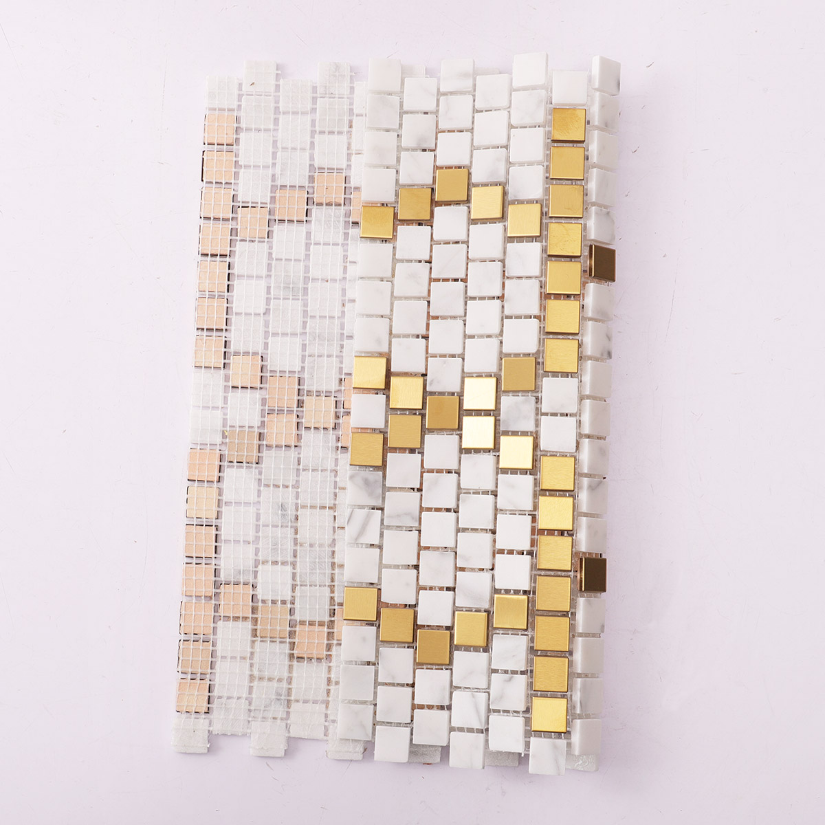 Back side of metal and white marble pixel art mosaic tiles, showing fold.