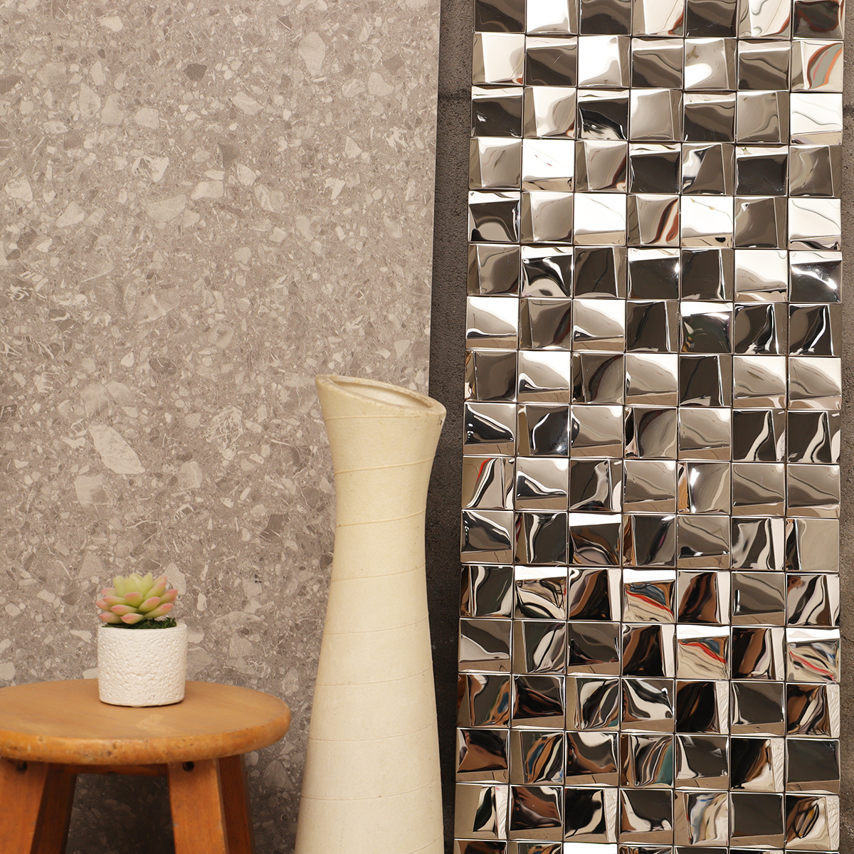 Scene of silver stainless steel square mosaic wall tiles paired with gray ceramic tiles.