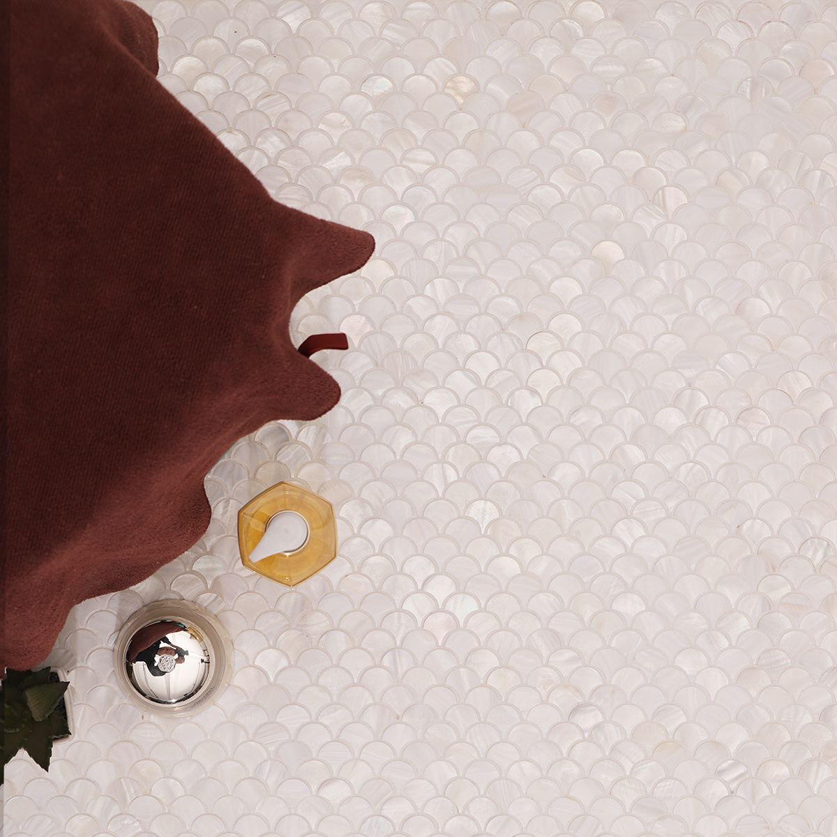 Close-up view of white fish scale mother of pearl mosaic tiles showing texture and shine.