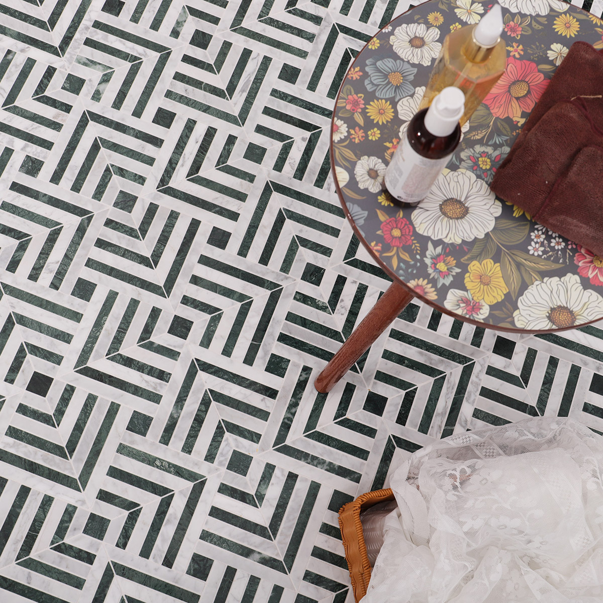 Detailed view of white and green chevron pattern marble mosaic tiles arranged on the floor.