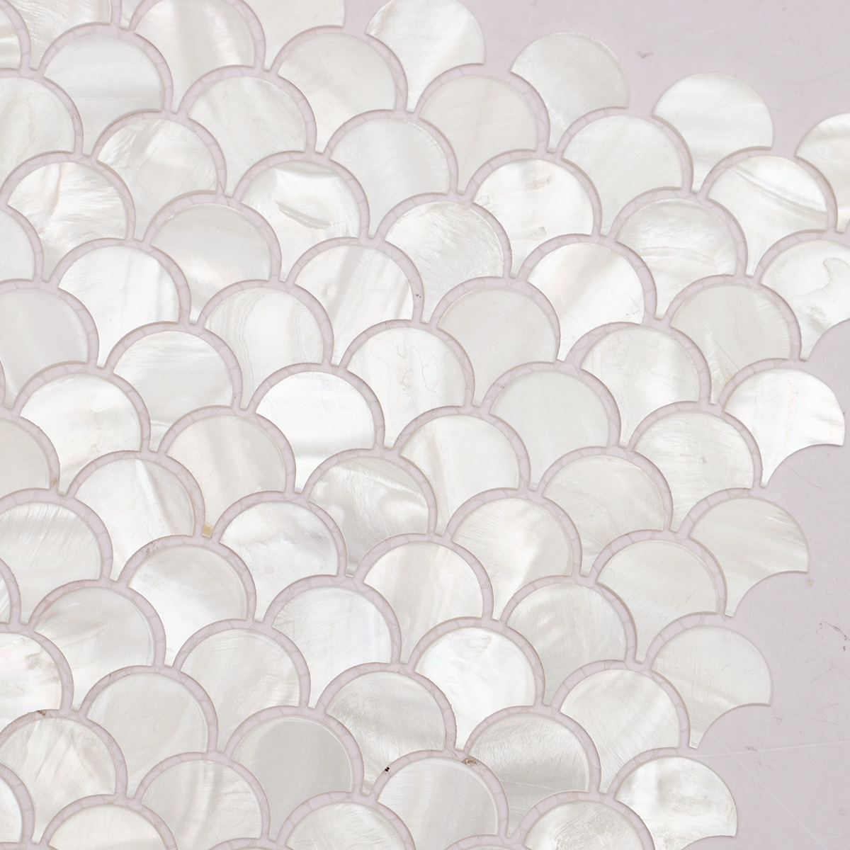 Close-up view of a mother-of-pearl mosaic tile in a fish scale shape