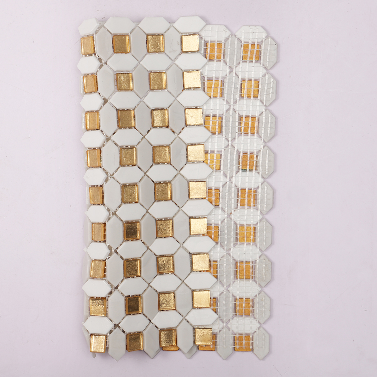 Back side of a sheet of gold and white glass mosaic tiles, showing fold.