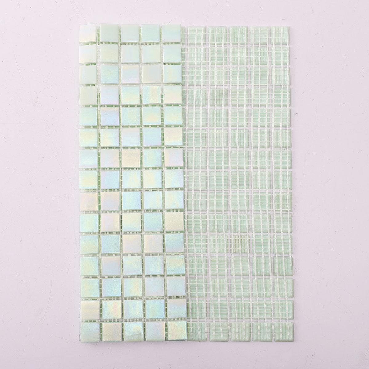 Back side of green iridescent square glass mosaic tiles, showing fold and mesh mounted