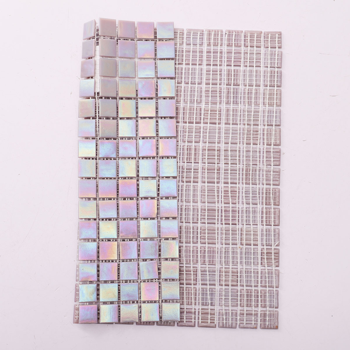 Back side of purple iridescent square glass mosaic tiles, showing fold and mesh mounted