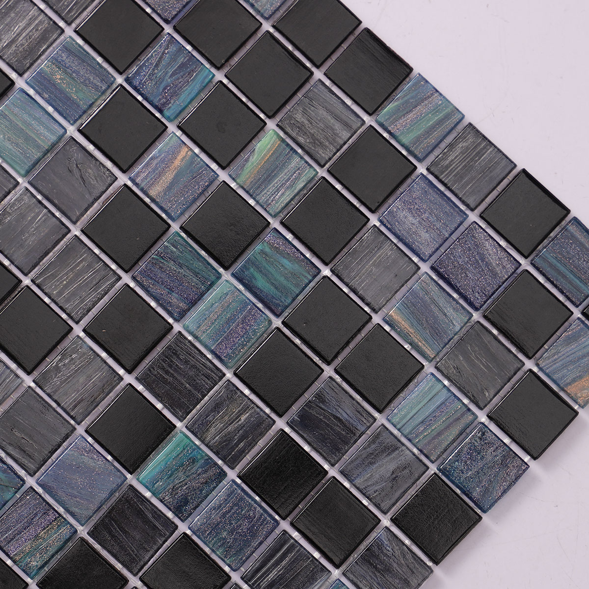 Close-up side view of green and black joint square glass mosaic tiles