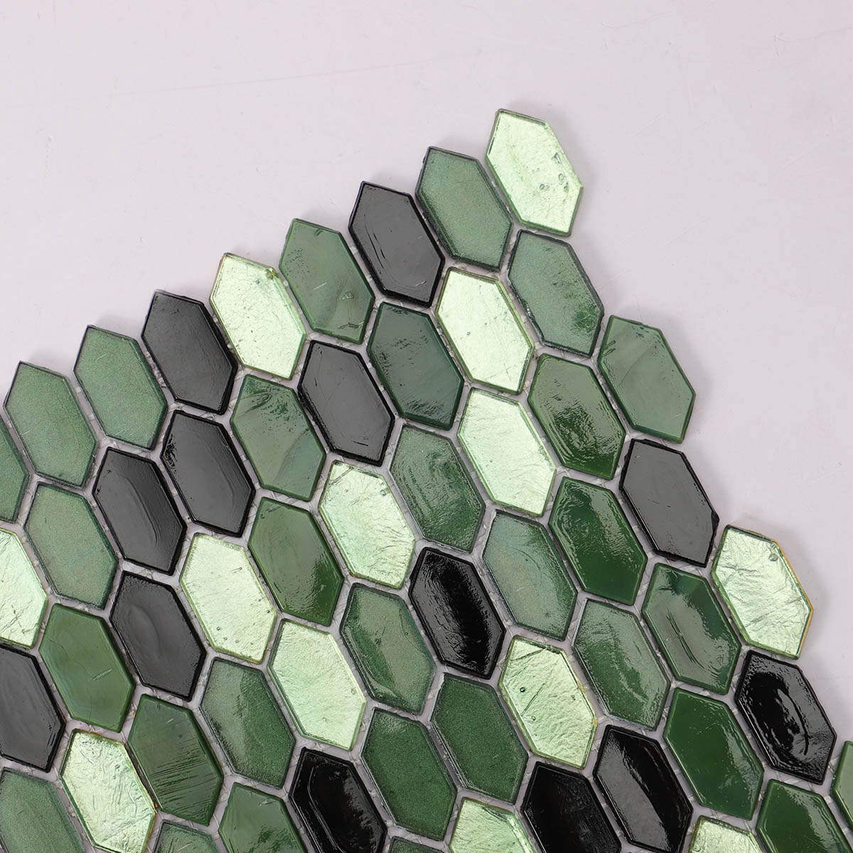 Close-up side view of mini picket green and black glossy glass mosaic tiles