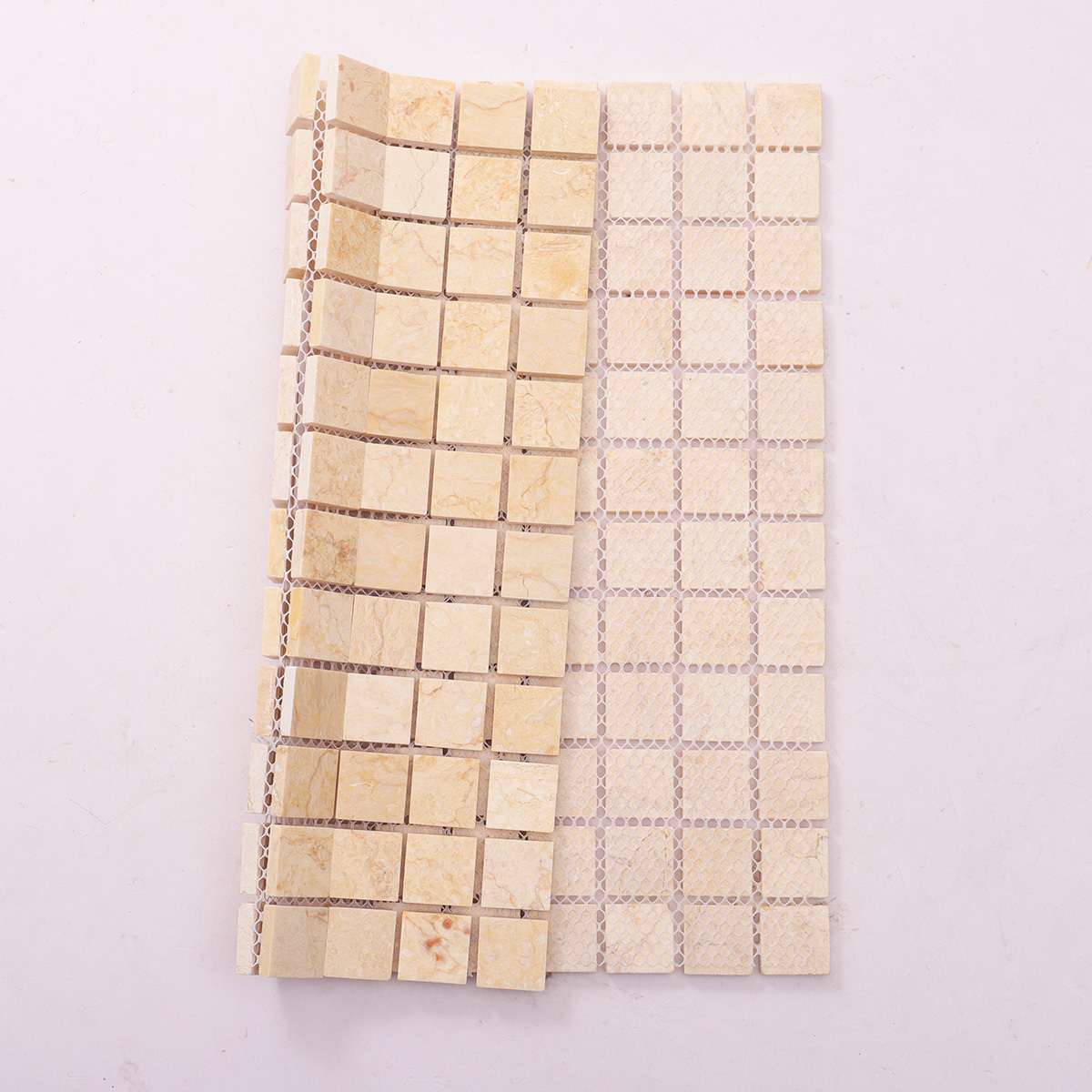 Folded back side of Crema Marfil square marble mosaic tiles.