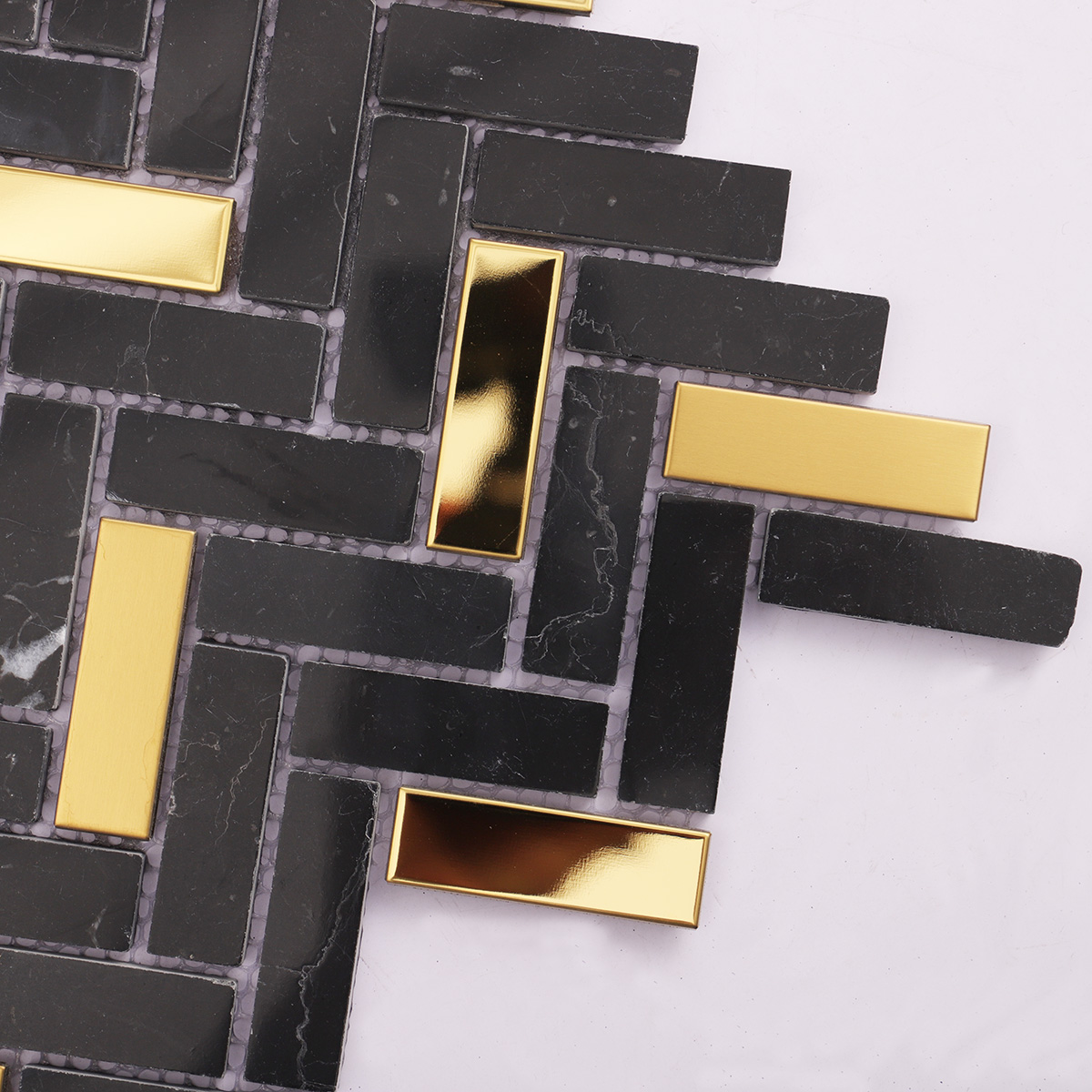 Close-up of black marble and gold metal gradient mosaic tiles