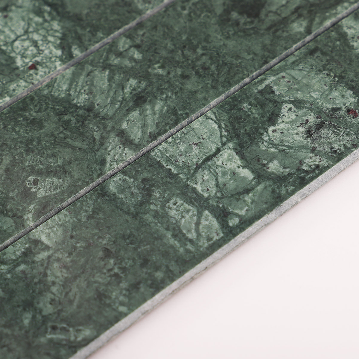 Macro close-up of long strip dark green marble mosaic tiles.