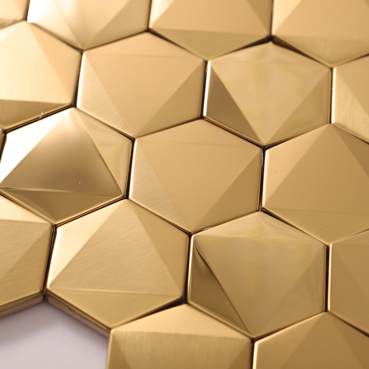 Close-up of hexagon gold 3D stainless steel mosaic tiles.