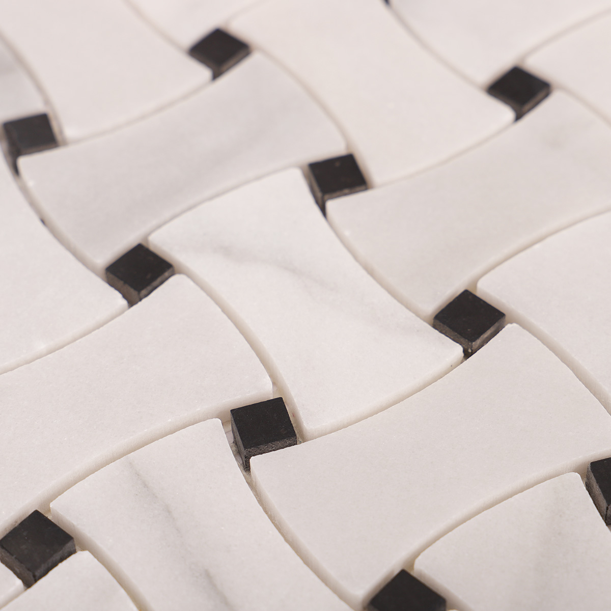 Macro close-up of Carrara white basketweave marble mosaic tiles with black dots