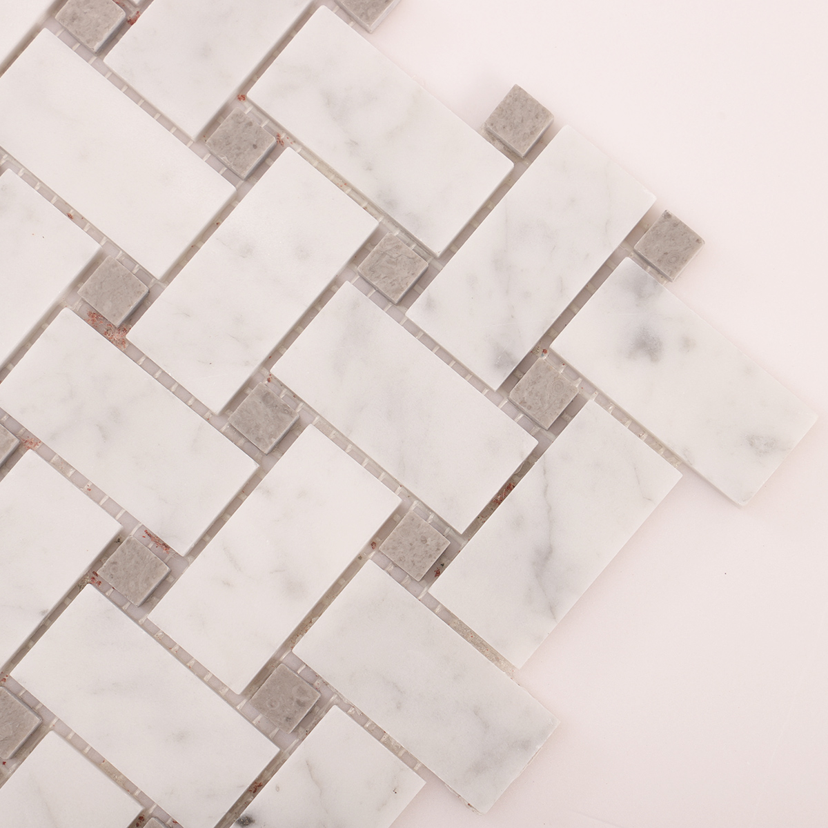 Close-up view of Carrara white basketweave marble mosaic tiles.