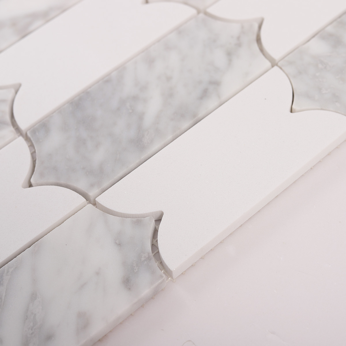 Side close-up view of Carrara white natural stone mosaic tiles, showing texture and thickness