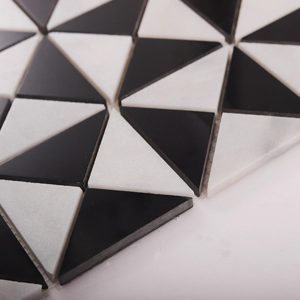 Side close-up view of Carrara White and Black Triangle Windmill marble mosaic tiles