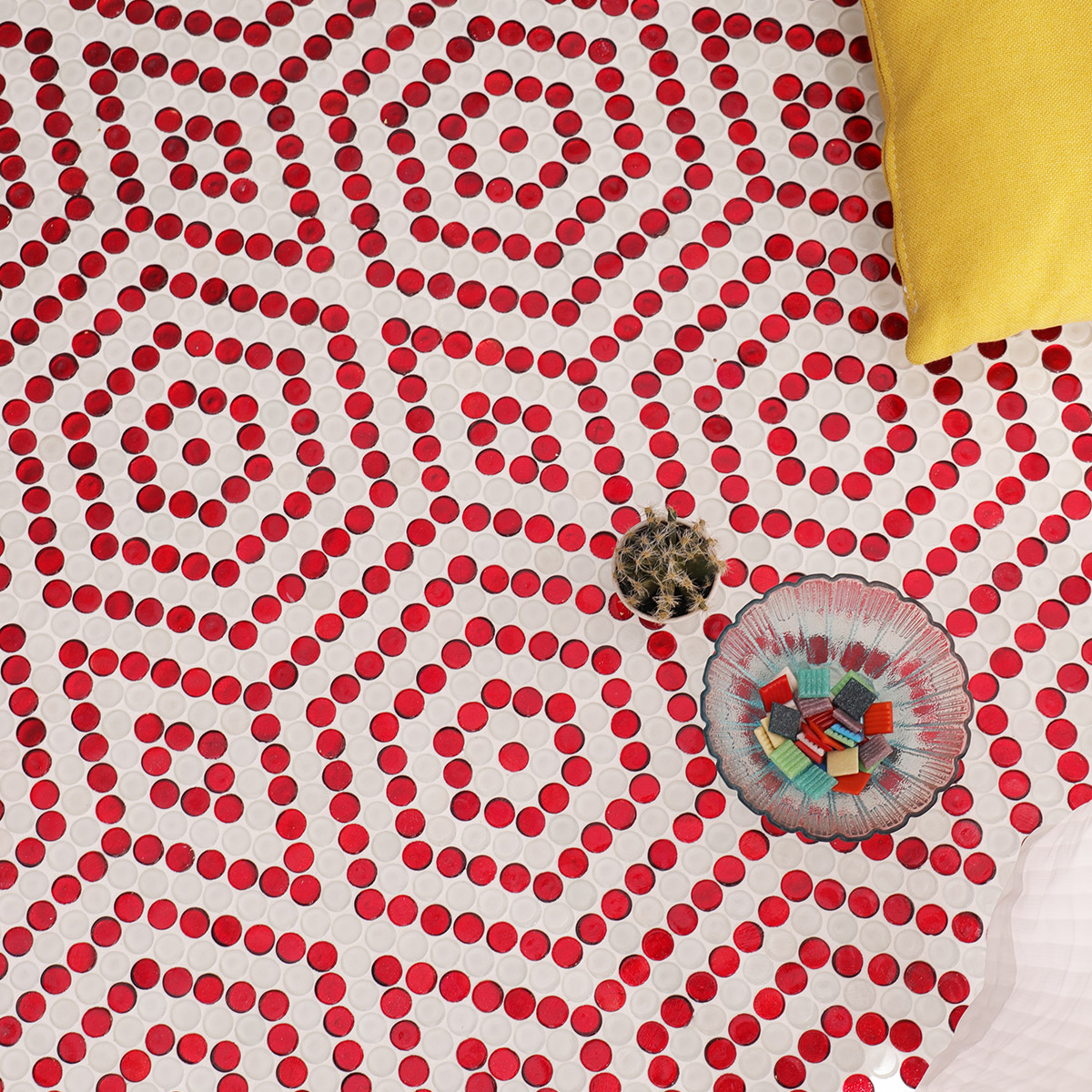 Floor setting with the red and white hexagonal mosaic design, featuring yellow pillow.