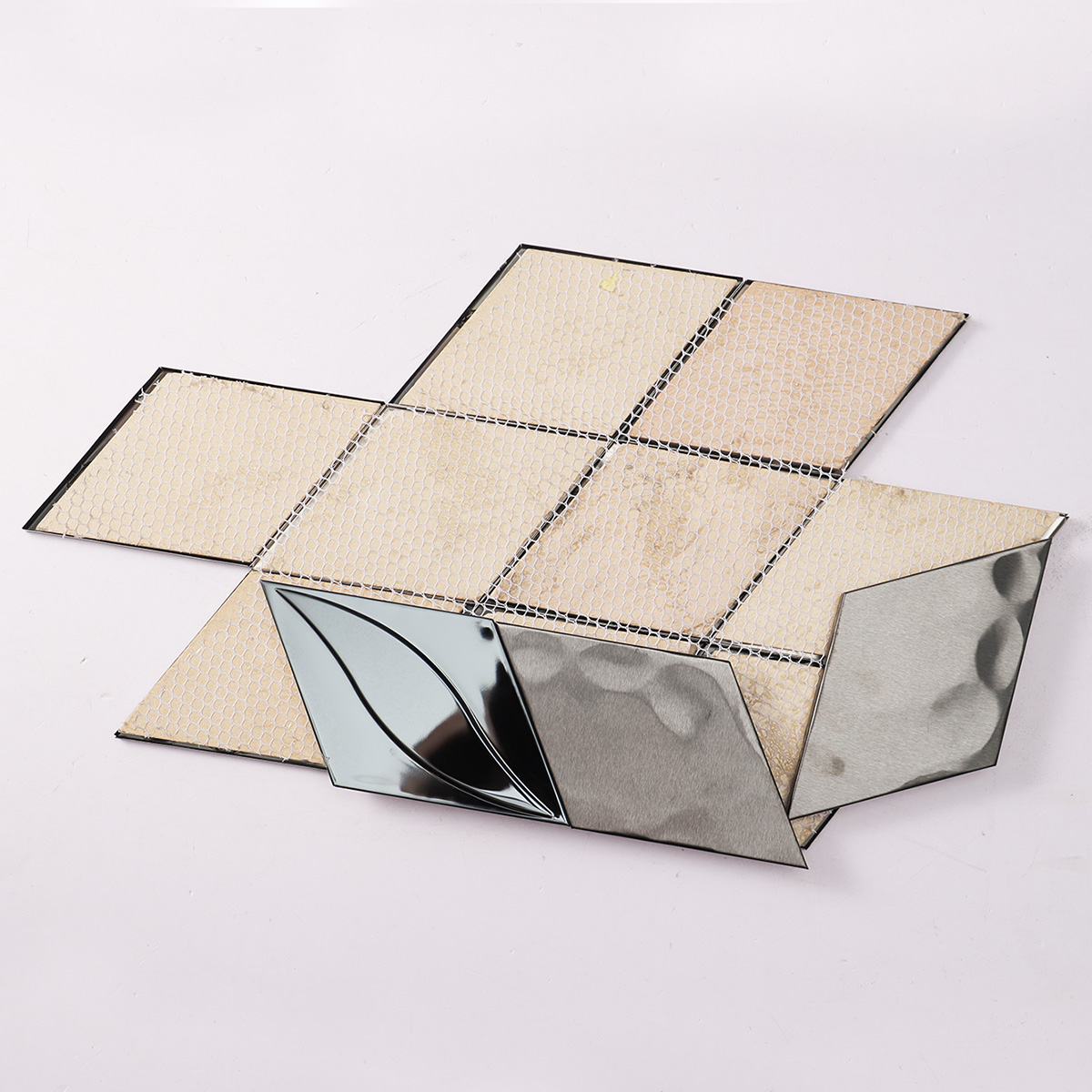 Folded back side of black metal stainless steel diamond mosaic tiles.