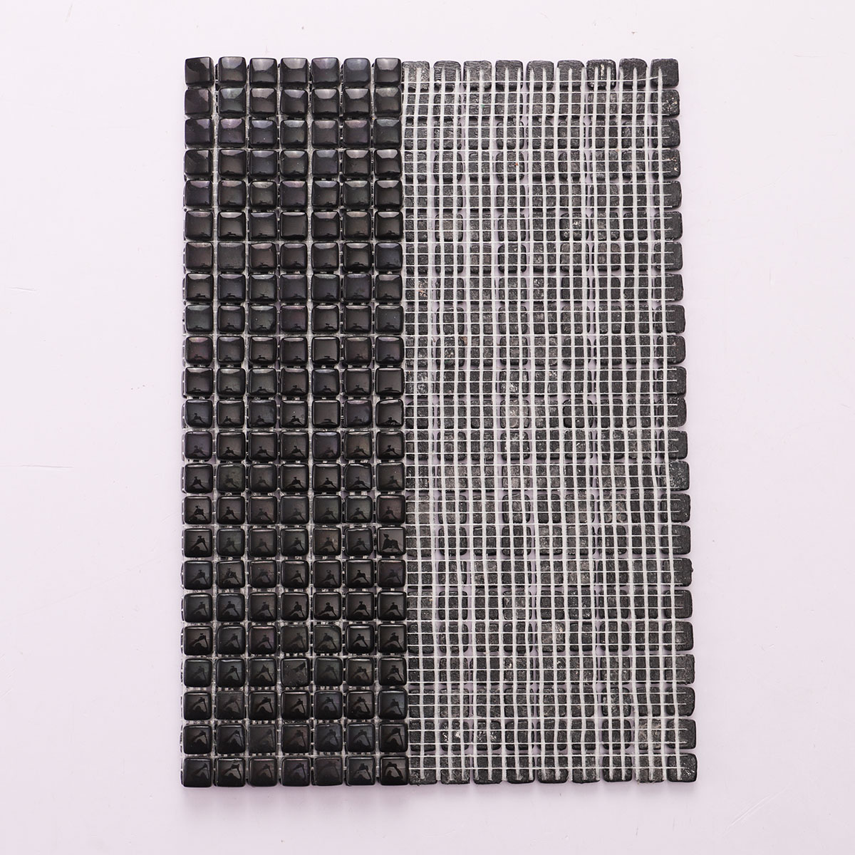 Back side of tiny black glossy recycled glass mosaic tiles, folded.
