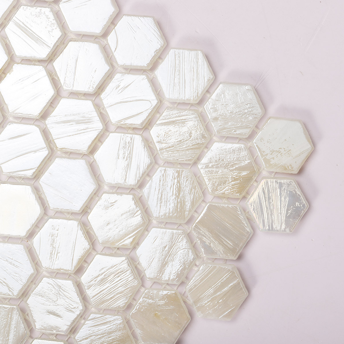 Detailed close-up of beige flash hexagon glass mosaic tiles.