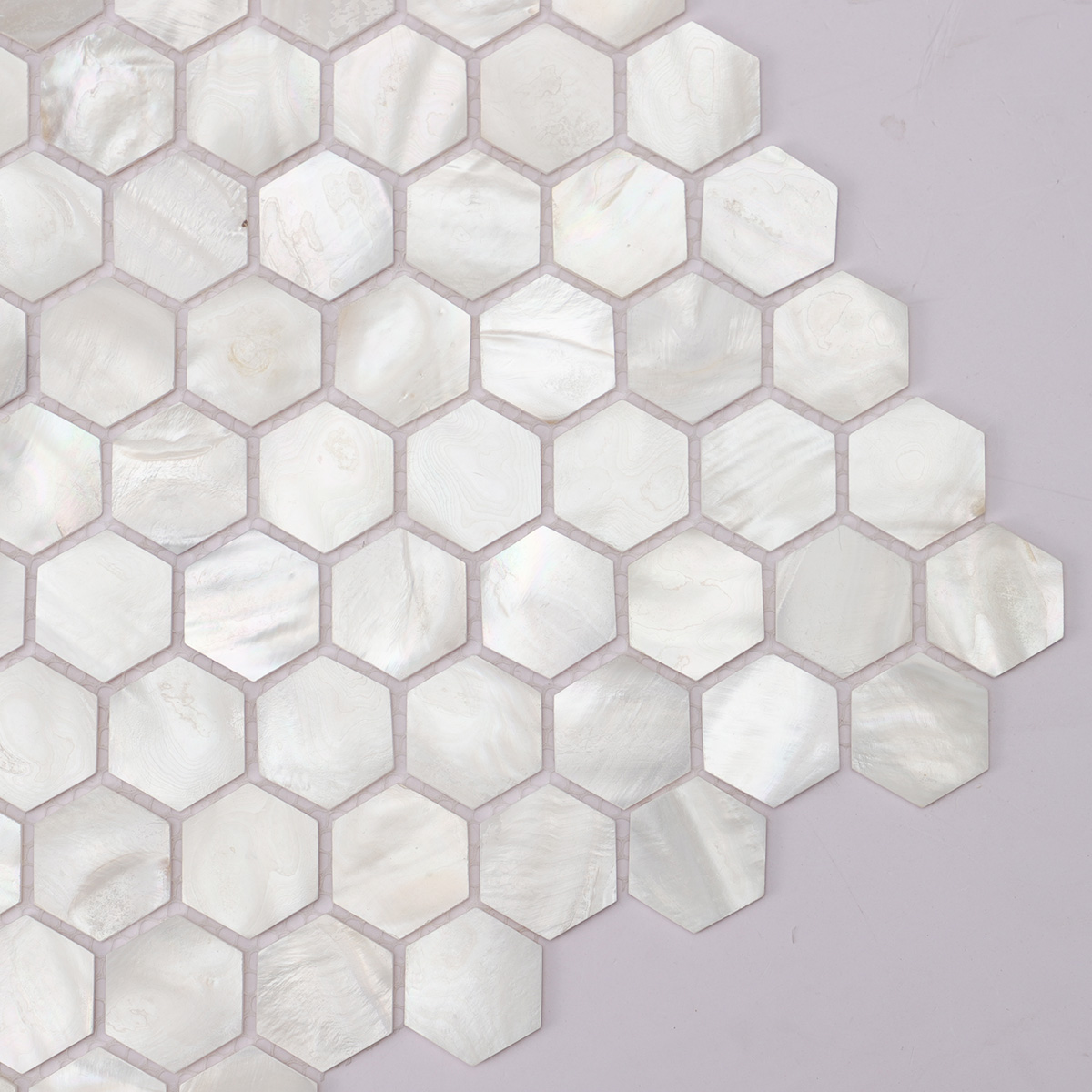 Close-up of white hexagon mother of pearl mosaic tiles.