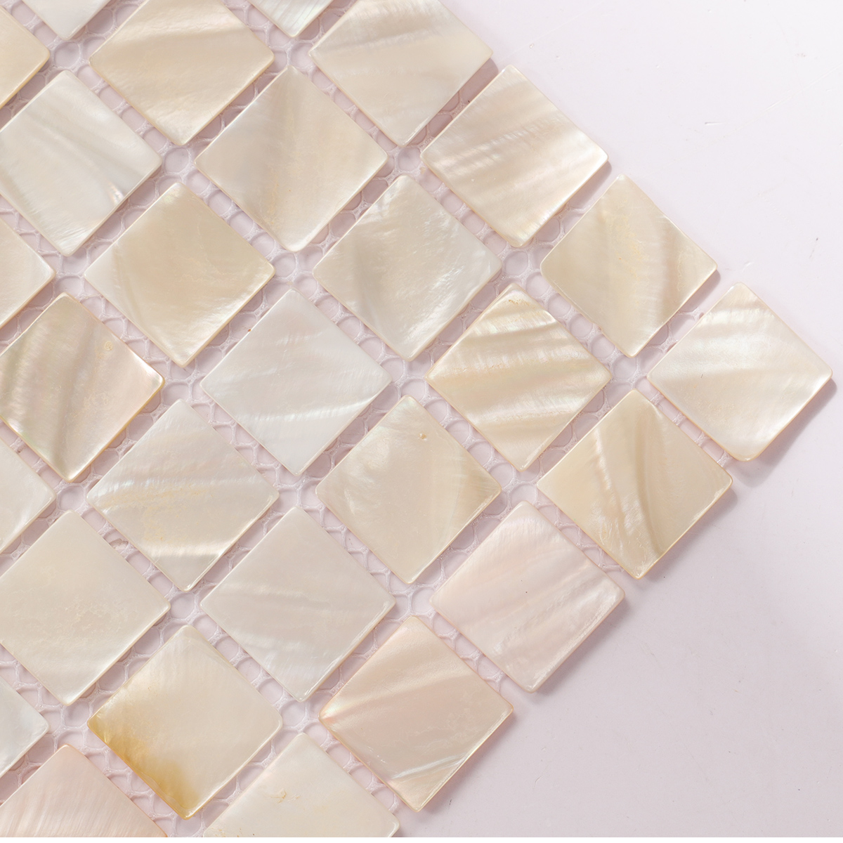 Close-up of beige iridescent mother of pearl square mosaic tile.