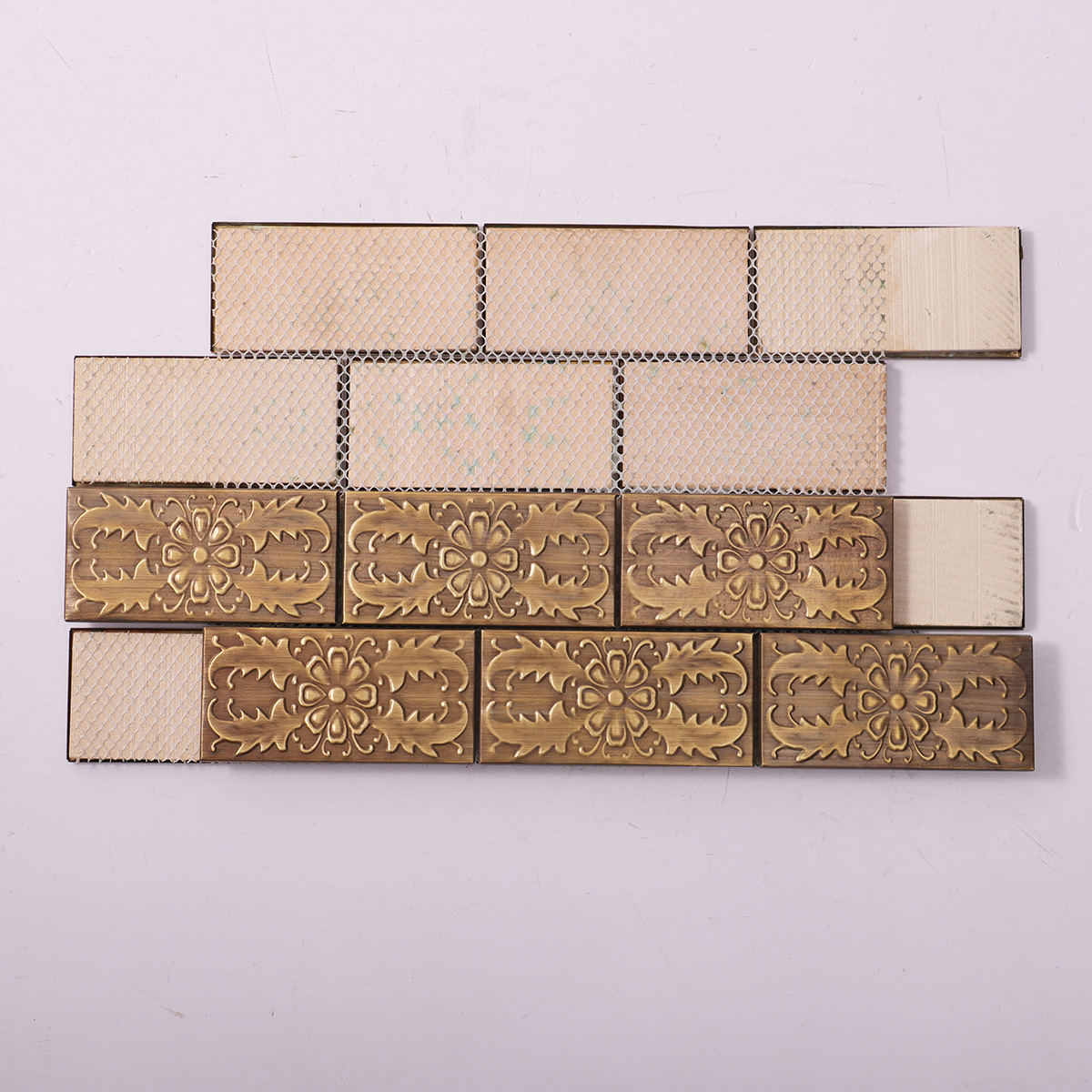 Back side of copper subway mosaic with decorative patterns, showing fold