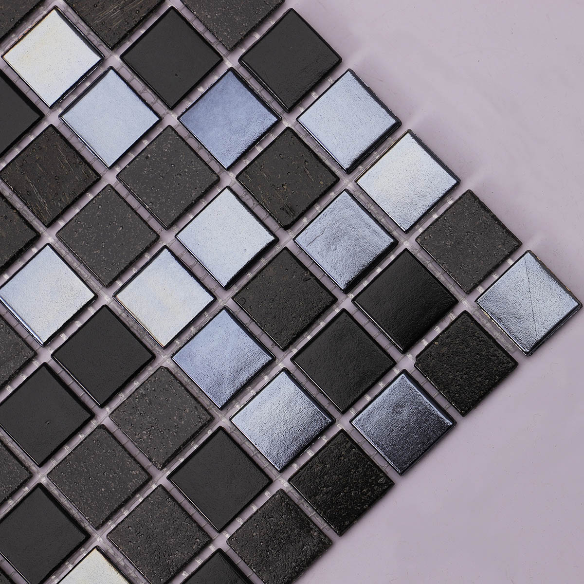 Detailed side close-up of black square glass mosaic tiles