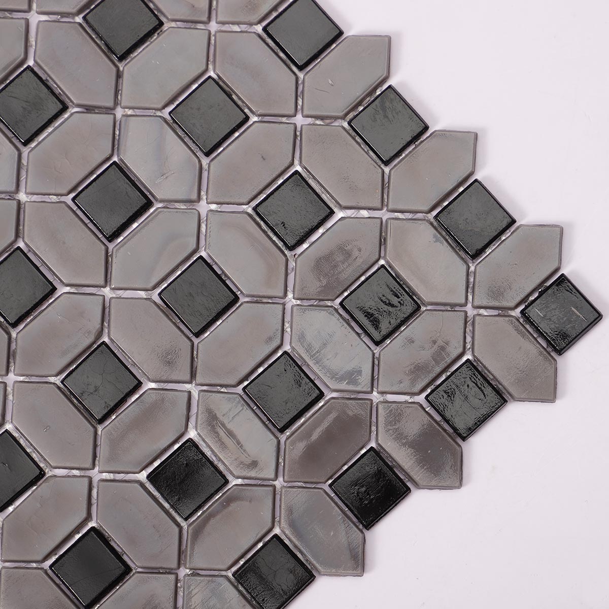 Side close-up of gray picket and black square glass mosaic tiles