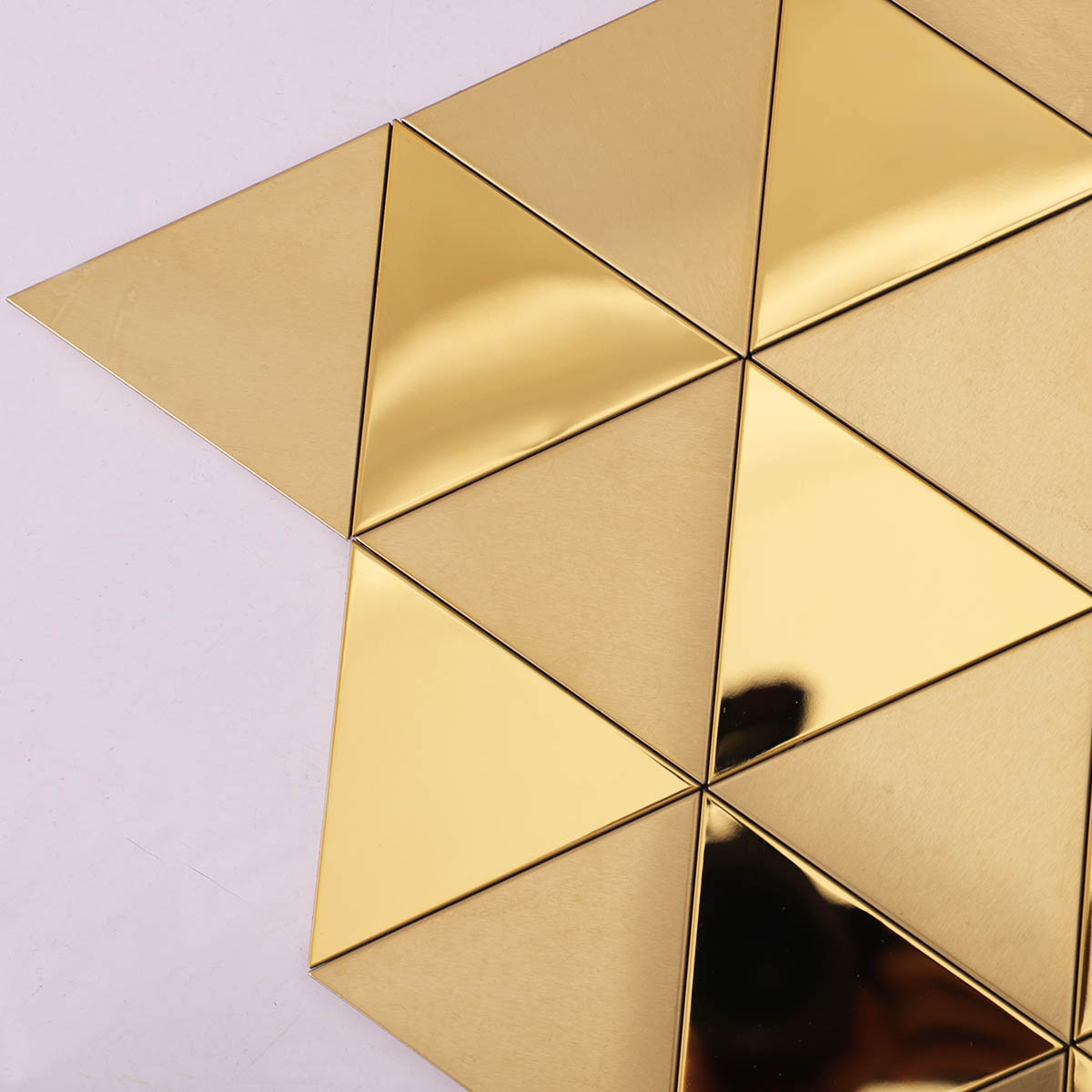 Detailed close-up side view of gold triangle metal mosaic wall tiles