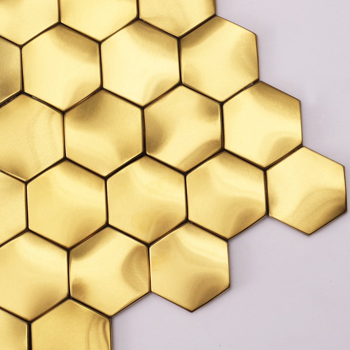 Close-up of 3D gold stainless steel hexagon mosaic wall tiles.
