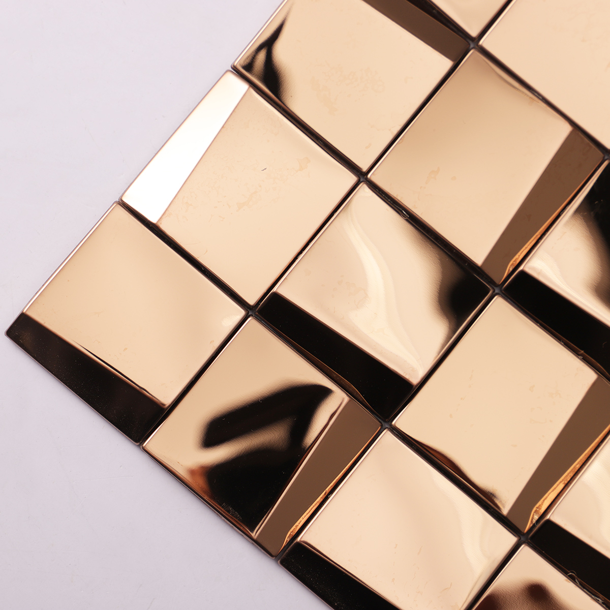 Mirror gold metal square mosaic tiles close-up.