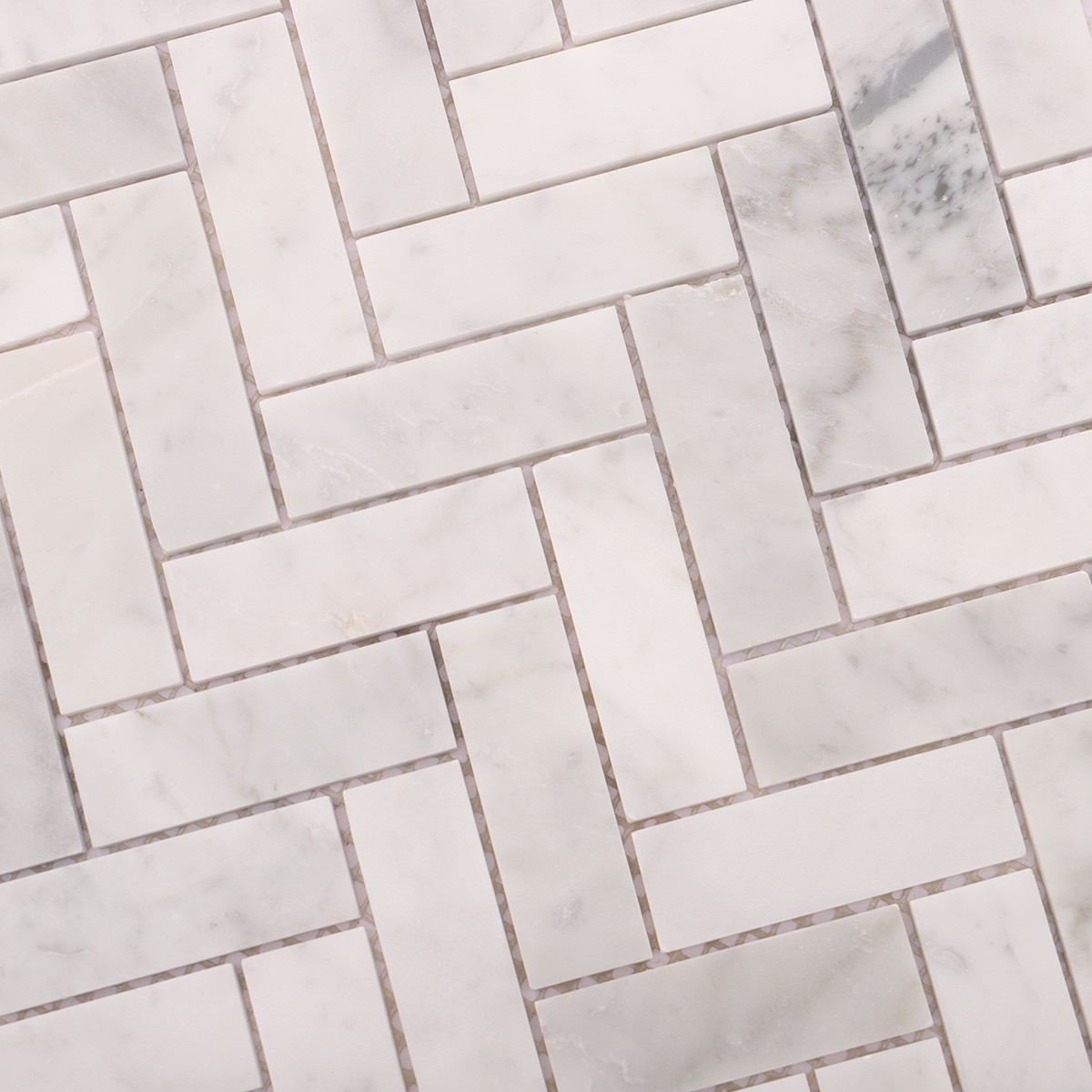 Close-up of polished herringbone Carrara white marble mosaic tiles
