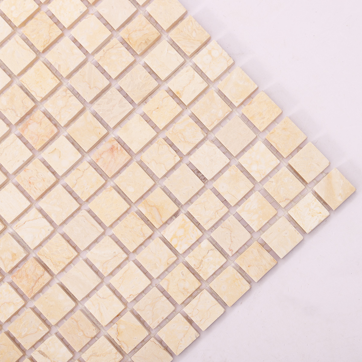 Close-up of Crema Marfil polished marble mosaic tiles.