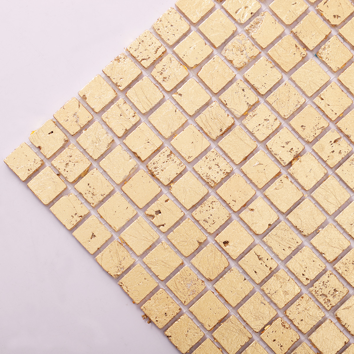 Close-up of gold foil square travertine mosaic tiles.