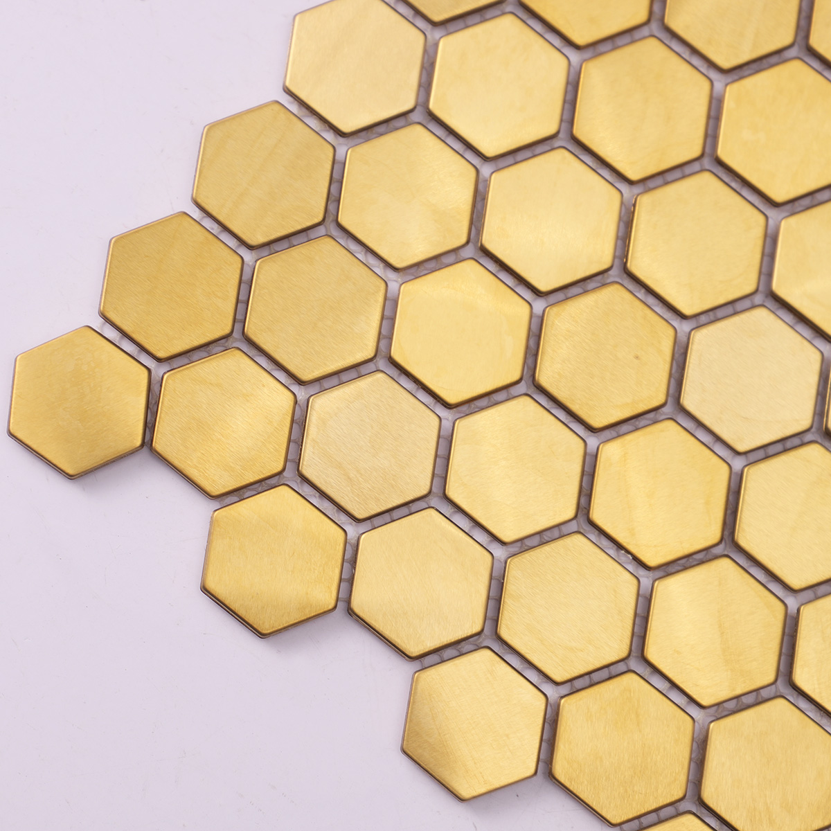 Close-up of hexagon gold brushed mirror stainless steel mosaic tiles.