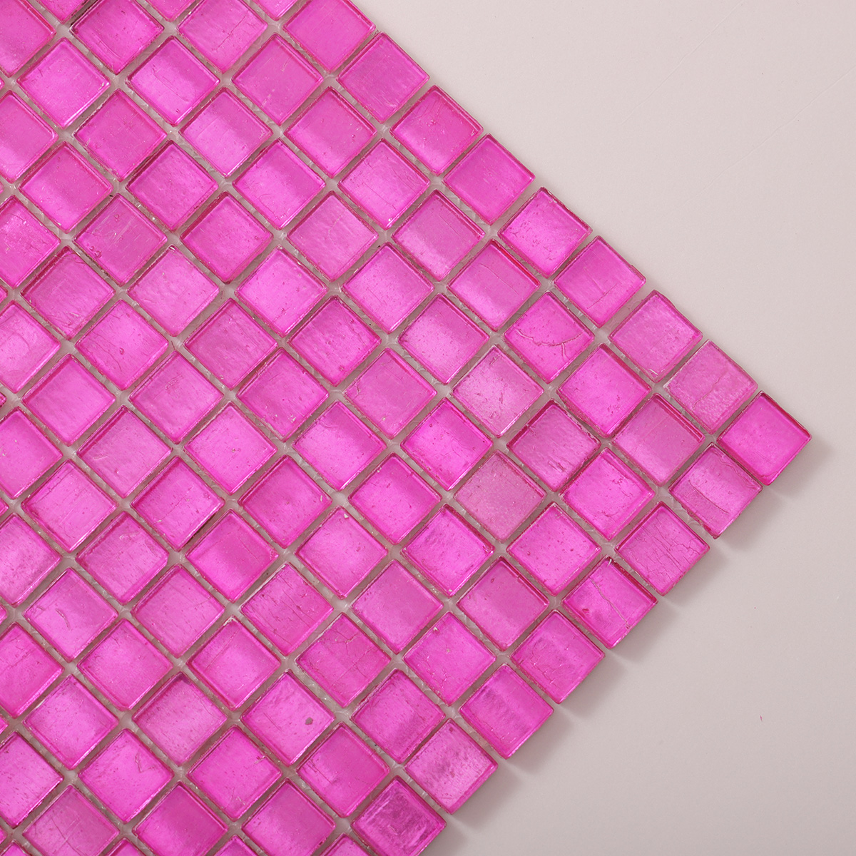 Detailed close-up of pink foil square glass mosaic tiles.