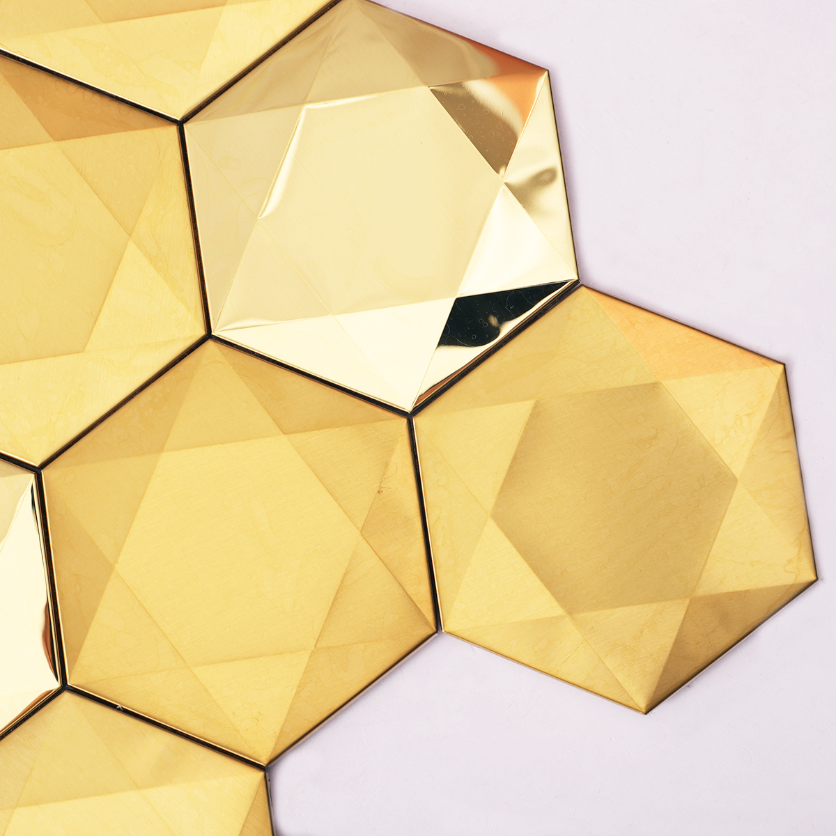 Close-up of big hexagon 3D gold stainless steel metal mosaic tiles.