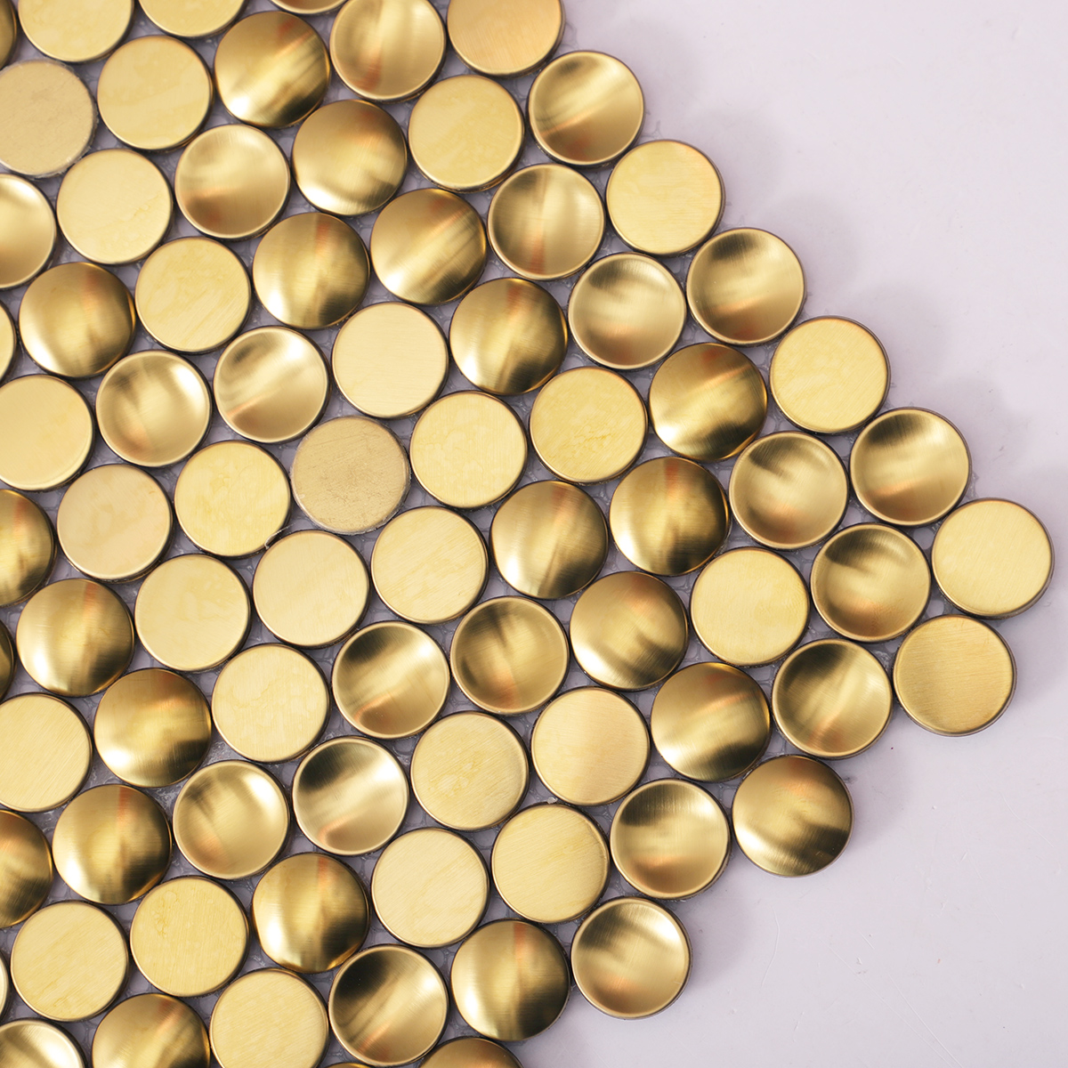Detailed close-up of penny round gold metal mosaic tile.