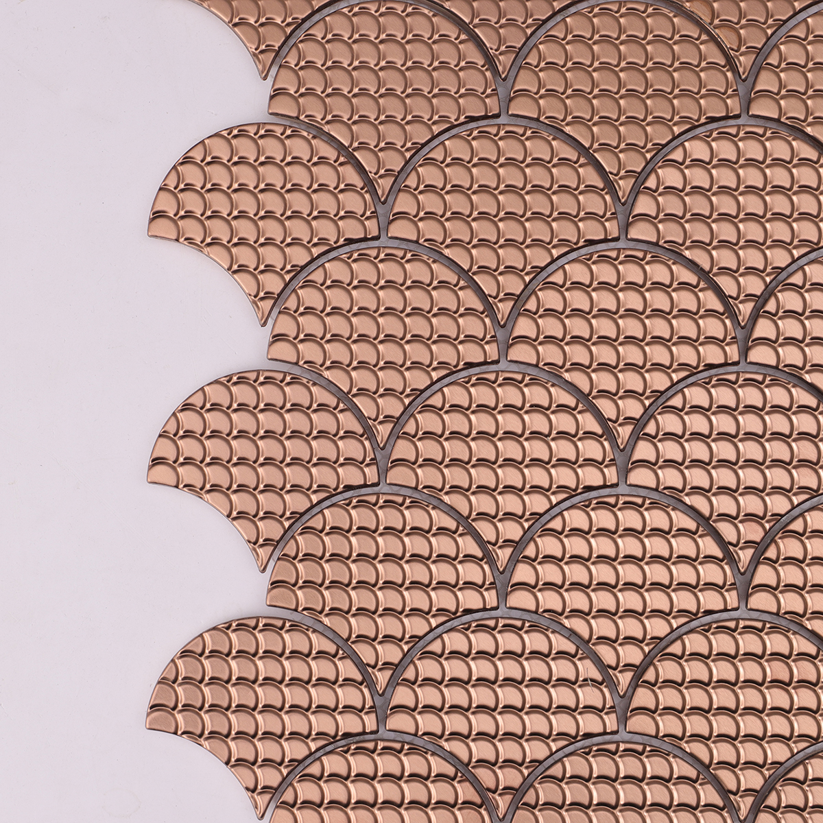 Detailed close-up of rose gold metal scallop mosaic tiles.