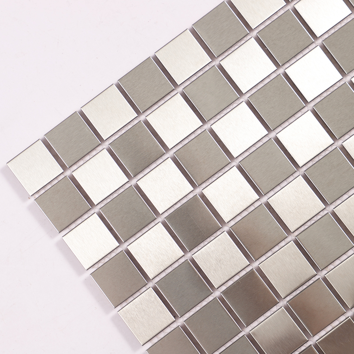 Close-up of silver brushed stainless steel square mosaic tiles.