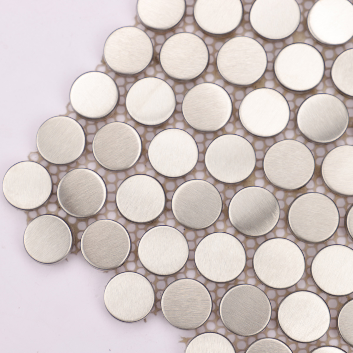 Close-up of brushed silver penny rounds metal mosaic tiles.