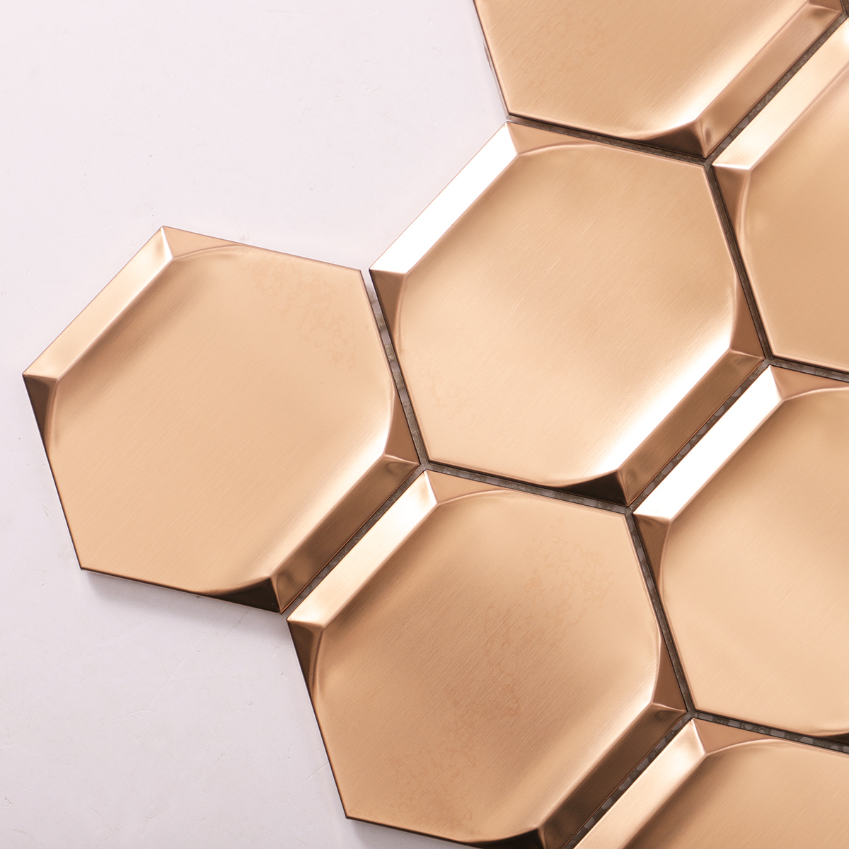 Close-up of rose gold 3D stainless steel hexagon mosaic tiles.