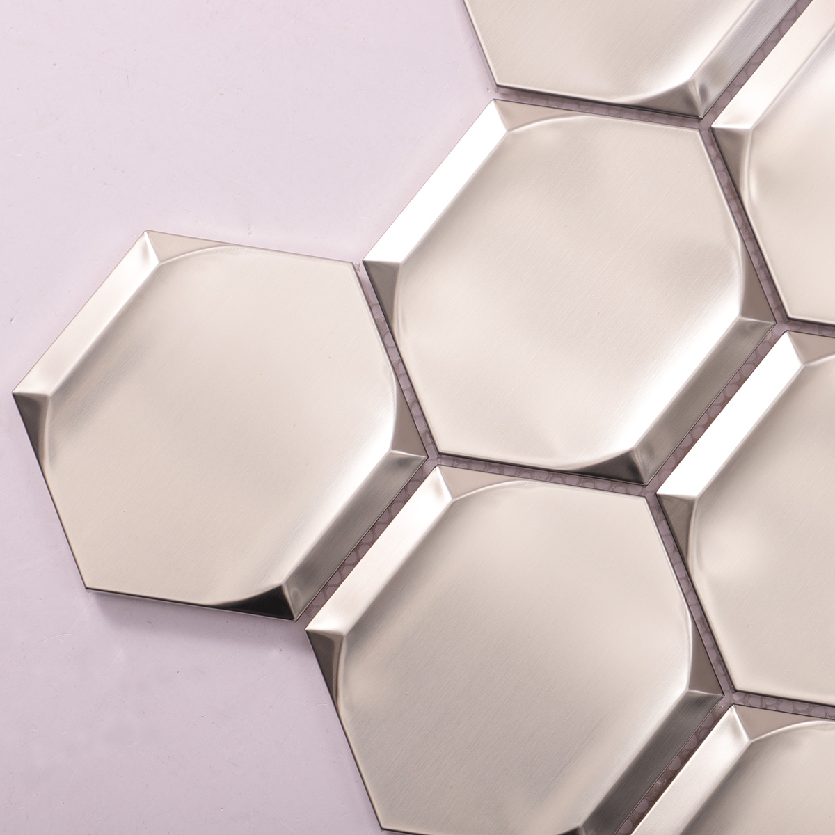 Close-up of silver 3D stainless steel hexagon mosaic tiles.